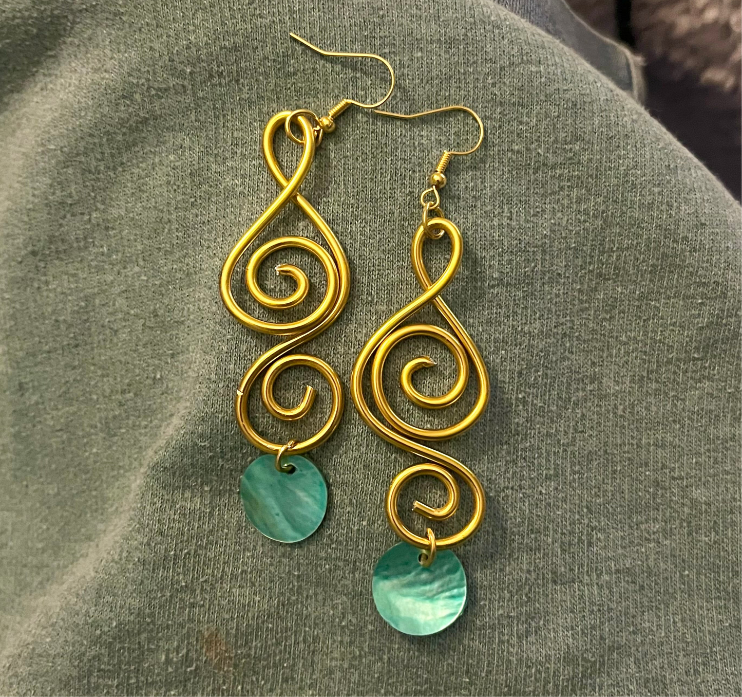 A aqua sister pair of gold swirls